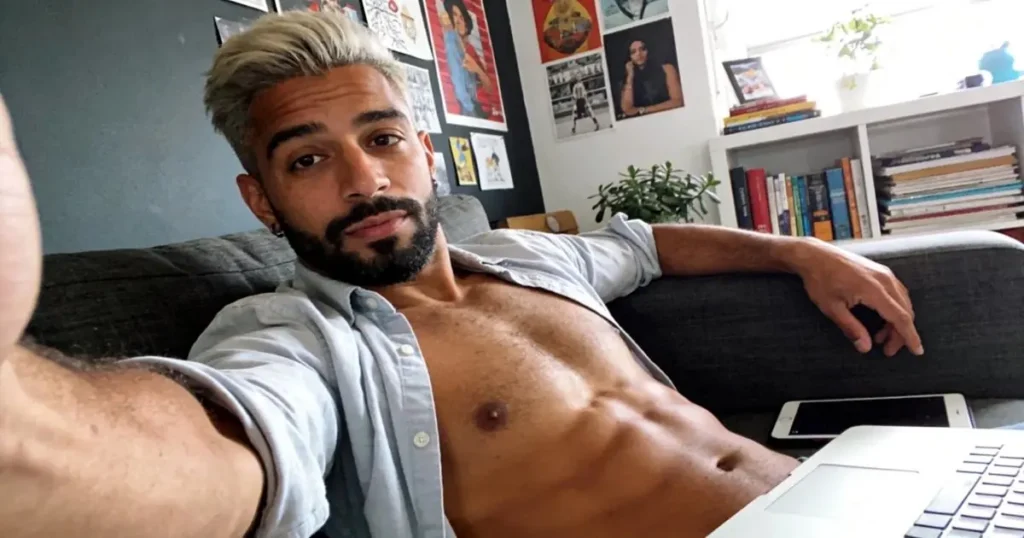 Shirtless man chatting on his phone at home