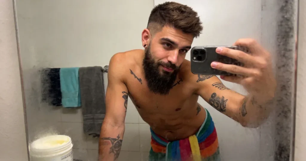 Bearded man taking a mirror selfie at home