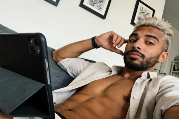 Shirtless man using a tablet for private gay chat