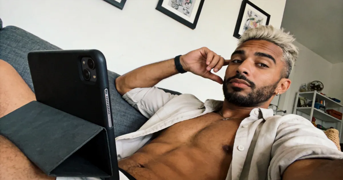 Shirtless man using a tablet for private gay chat